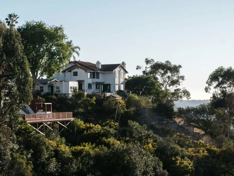 Home on a hillside surrounded by trees and brush in California